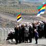 On the border: Members of the Druze community on the Israeli-controlled sector of the Golan Heights use loud-hailers to talk to fellow Druze in Syria. Photo: Getty Images
