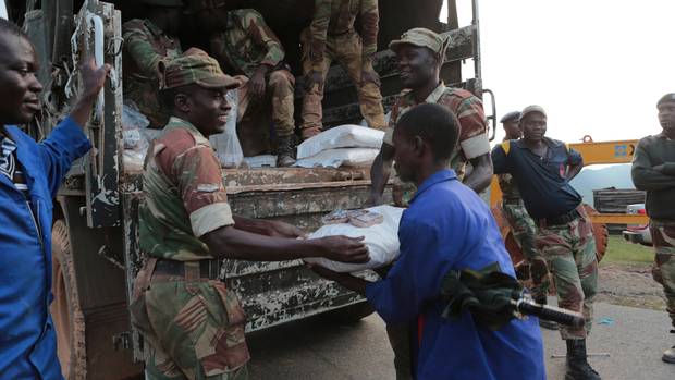Soldiers hand out food supplies in Zimbabwe (Tsvangirayi Mukwazhi/AP)