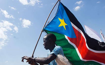 A man carries the South Sudan flag at Magateen