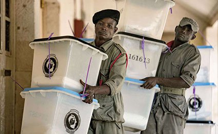 Security workers carry ballot boxes at a