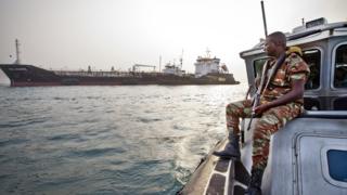 An anti-piracy team watches over a cargo ship off the coast of West Africa.