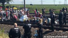 Protesters and police stand either side of railway tracks (picture-alliance/dpa)